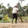 A man in red hat using an old style hoe.